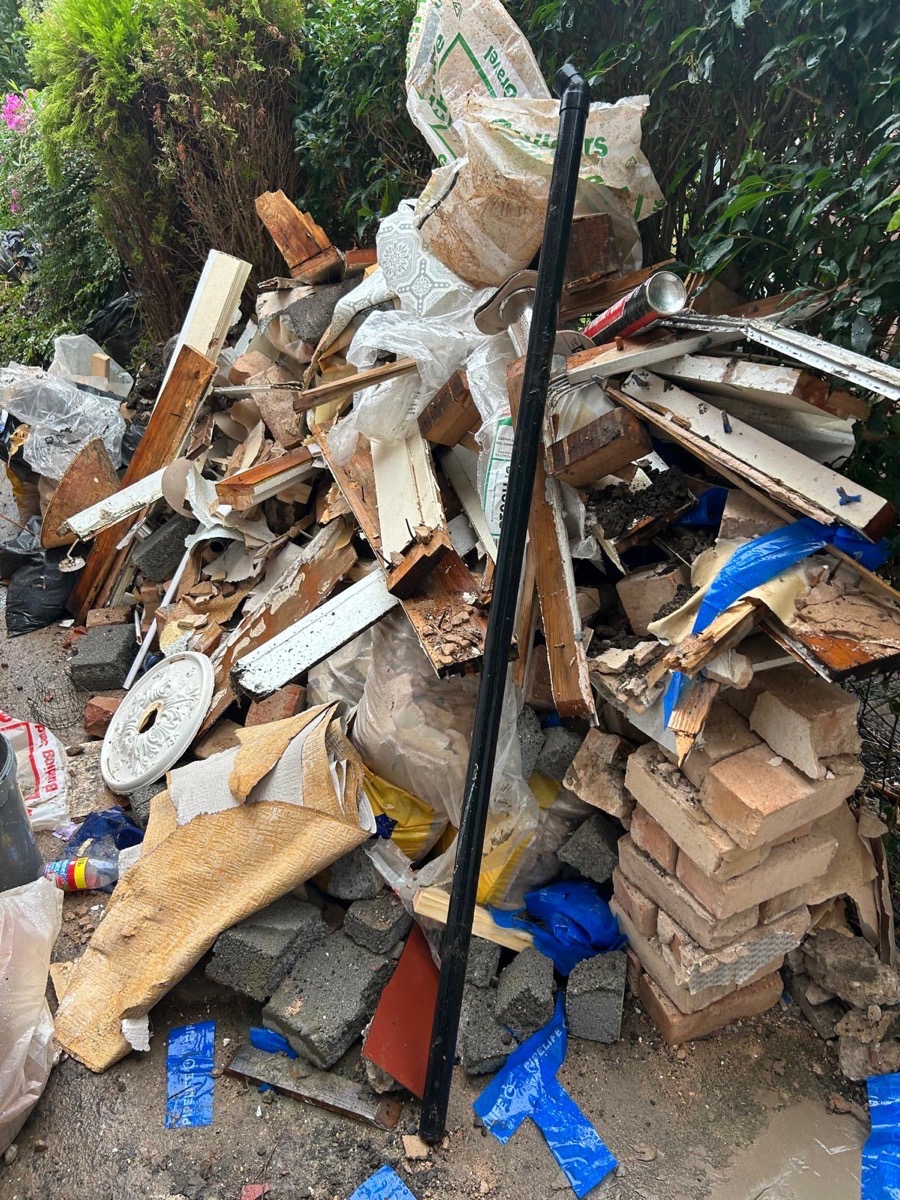 Brick rubble and timber stacked in a side passage before collection