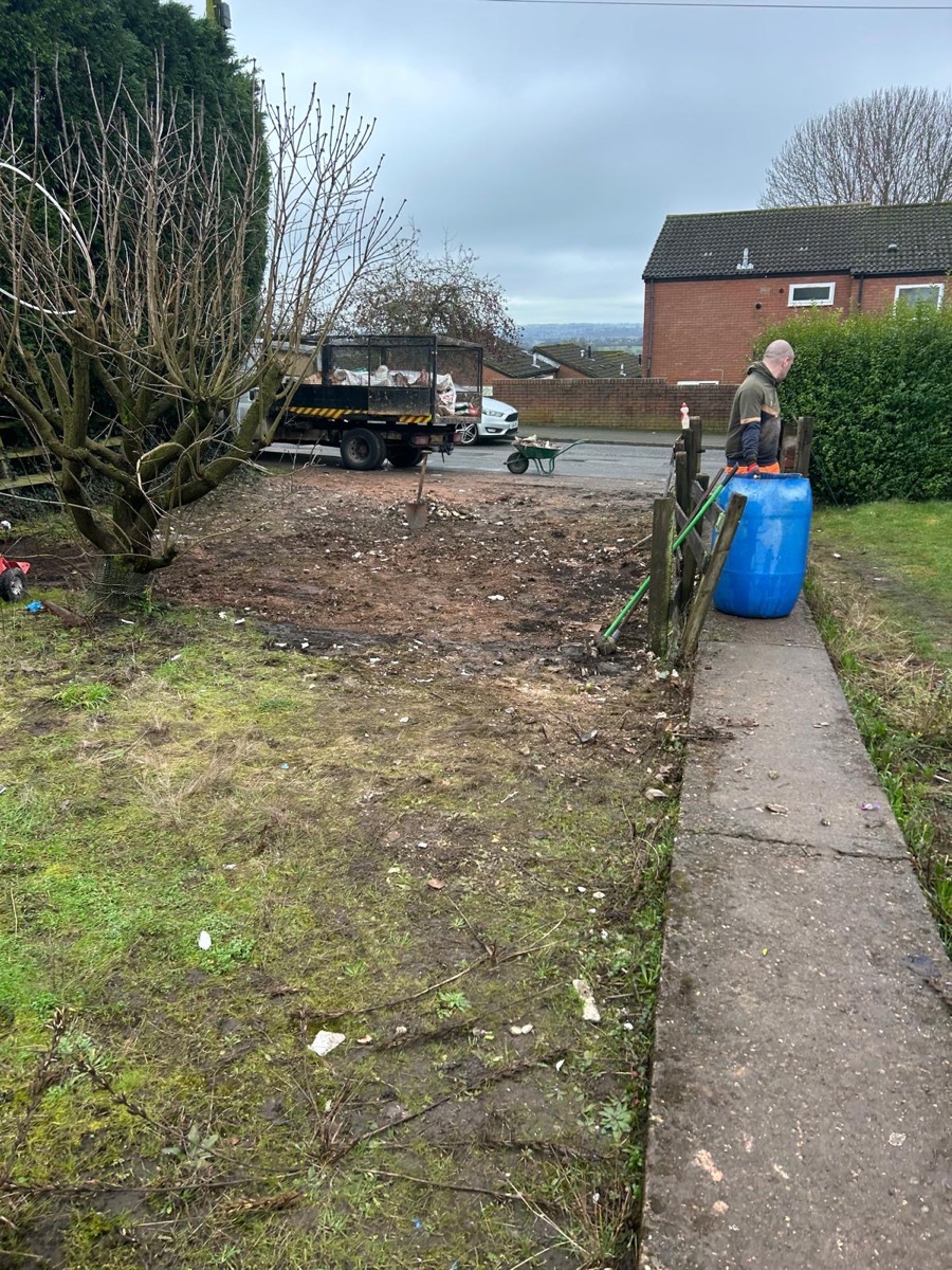 Garden mid-clearance, tipper trailer on the road and waste barrow to hand