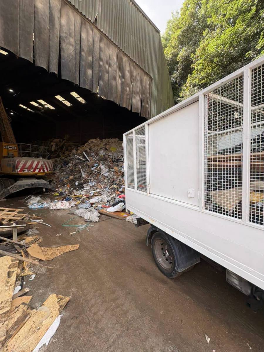 TWB's liveried tipper trailer backed up to the tipping floor inside a licensed waste transfer facility